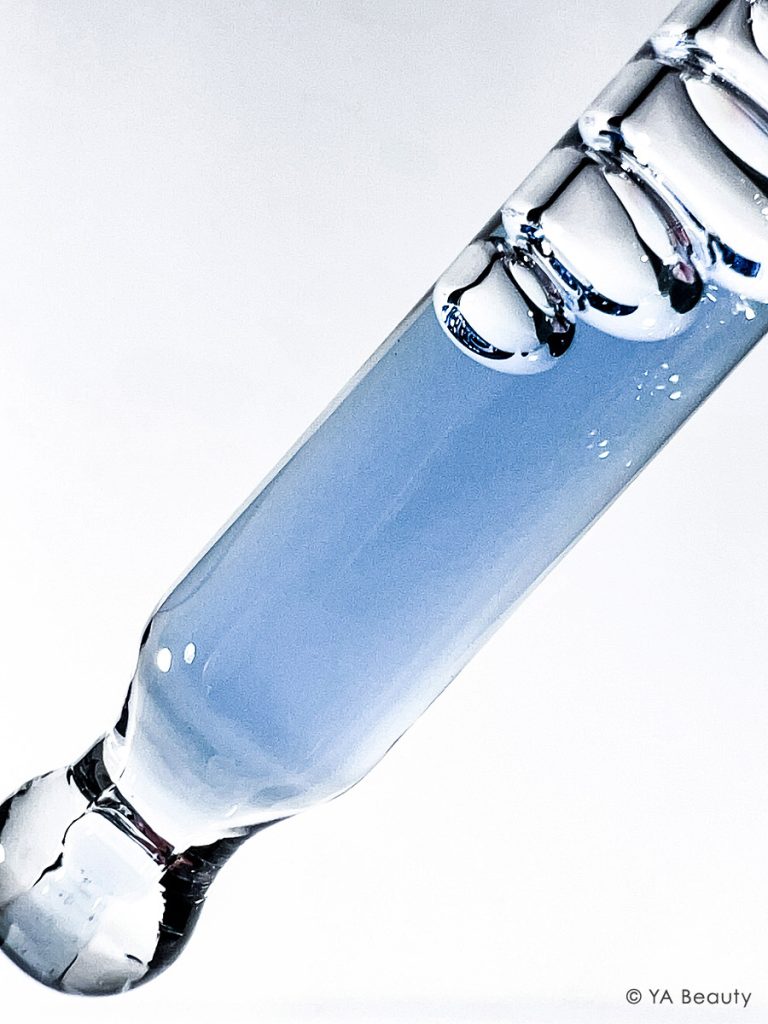 Closeup macro photography of blue liquid in a dropper with large bubbles. Featuring kbeauty brand Dear Klairs's Midnight Blue Youth Activating Drop Serum