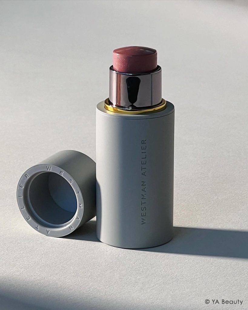 Striking photograph of Westman Atelier Baby Cheeks Blush Stick in Shade Petal, set against a clean, gray background.